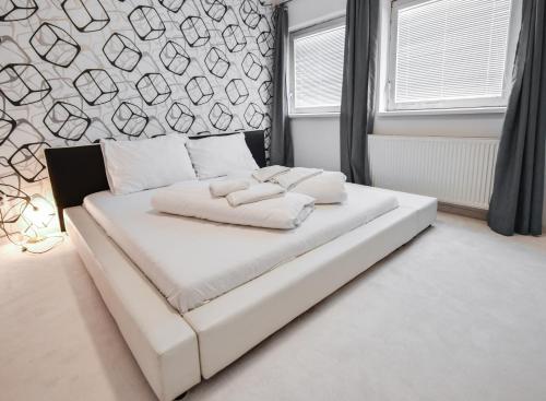 a white bed with two pillows on it in a bedroom at Botel Gracia in Bratislava