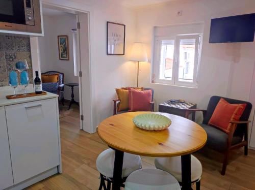 a living room with a table and a kitchen at Entre Muralhas - Cozy Apartment Elvas I in Elvas