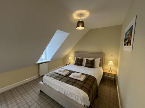 a bedroom with a large bed and a window at Ancluaran - Moat House 10 in Fort Augustus