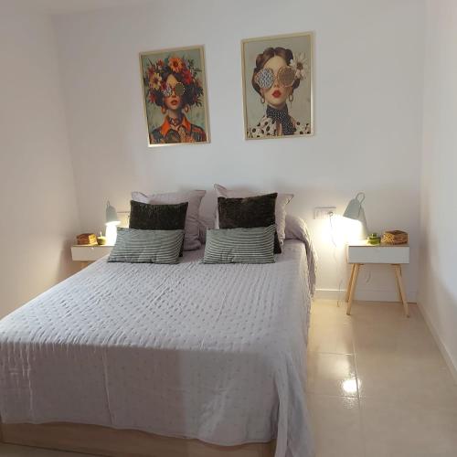 a bedroom with a white bed with two pictures on the wall at Casa de angil in Tivenys