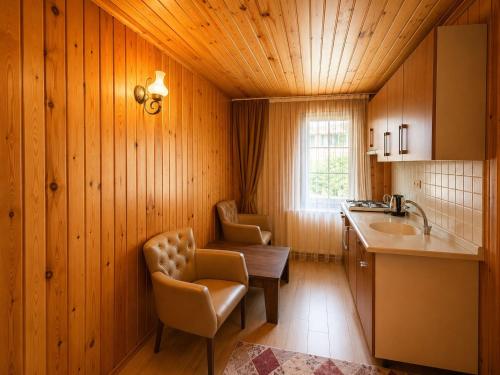 a kitchen with wooden walls and a wooden ceiling at Şekersu Otel in Çaykara