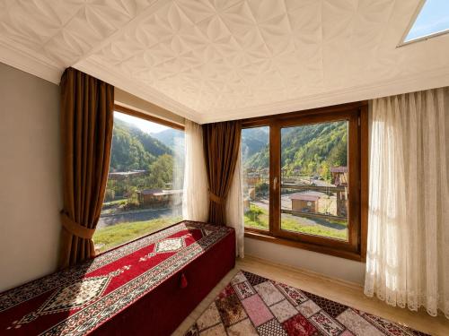 a bedroom with a large window with a view at Şekersu Otel in Çaykara