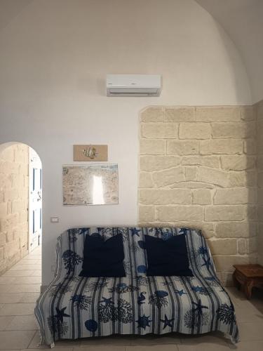 a bed in a room with a brick wall at CH Guest House in Vernole