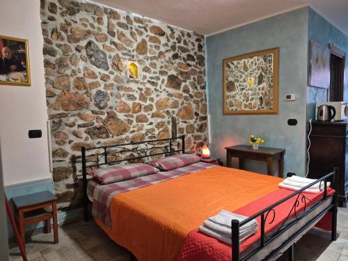 a bedroom with a bed in a stone wall at Ca' di Ruchitt in Cuasso Al Monte