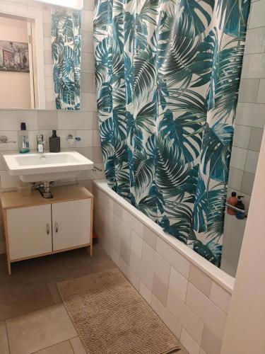 a bathroom with a sink and a shower curtain at Home luna &zeus in Lausanne