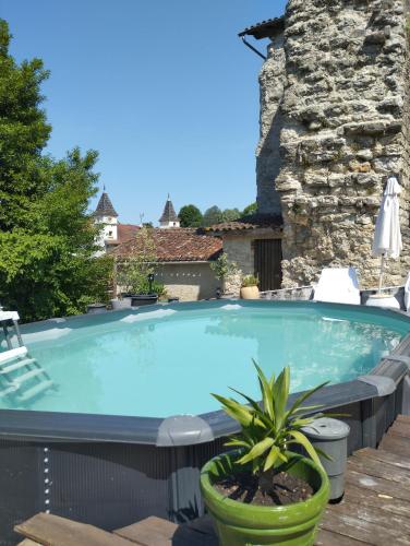 a large swimming pool on a deck with chairs and a plant at Iglesias Emmanuelle in Pradines