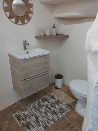 a bathroom with a sink and a toilet and a mirror at Iglesias Emmanuelle in Pradines