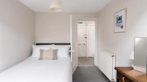 a bedroom with a white bed and a television at Bute Seaview in Rothesay