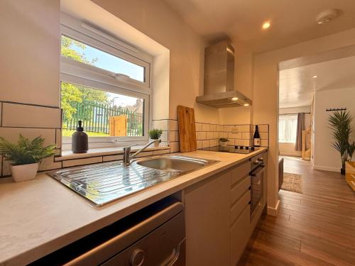 a kitchen with a sink and a large window at Unique Devon Cottages - Sunrise Cottage in Exmouth