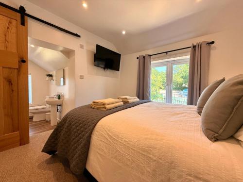 a bedroom with a large bed with a window at Unique Devon Cottages - Sunrise Cottage in Exmouth