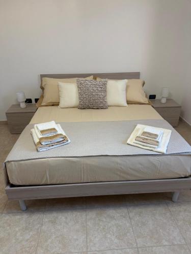 a bed in a room with two towels on it at La Dimora di Valesio in Torchiarolo