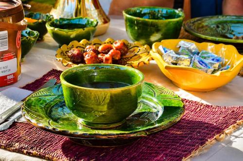 a table with a green cup and a plate of food at Kasbah Abdou in El Kelaa des Mgouna