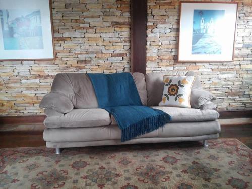a couch with a blue blanket sitting in a living room at Hotel Pousada Casa Grande in Ouro Preto