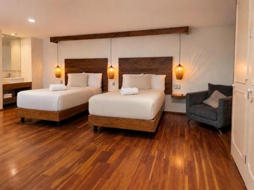 a hotel room with two beds and a chair at Terraza & Loft San Ángel in Mexico City