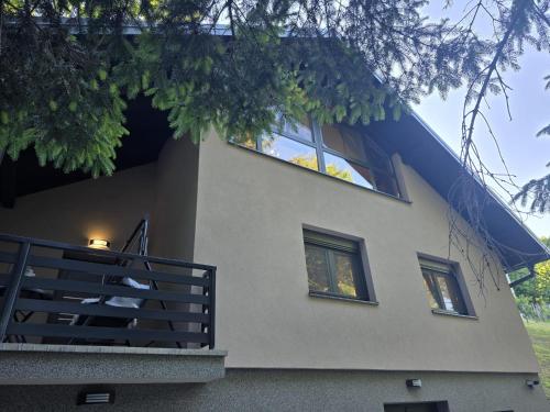 a house with three windows and a blue roof at Forest Magic in Duga Resa