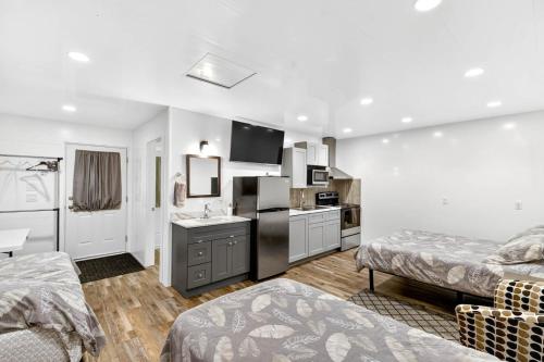 a bedroom with two beds and a kitchen with a sink at Chims Cabins - Port Alberni in Port Alberni