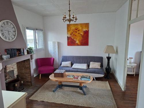 a living room with a couch and a table at havre de paix in Saint-Junien