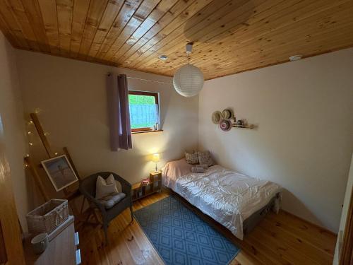 a bedroom with a bed and a wooden ceiling at Amaleczka Woda Las in Podjazdy
