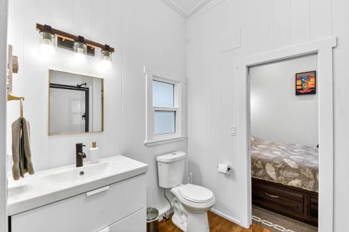 a bathroom with a toilet and a sink and a bed at Chims Cabins - Port Alberni in Port Alberni