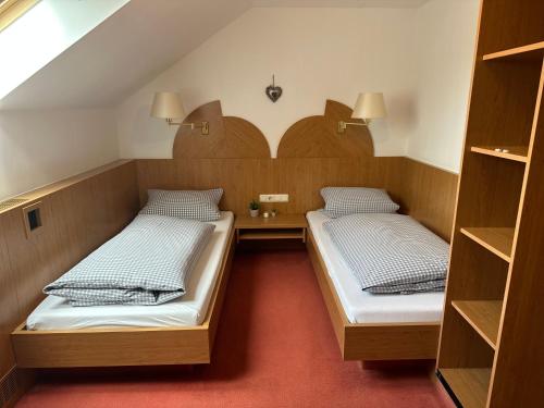 two beds in a small room with shelves at Hotel Restaurant Ampertal in Haag an der Amper