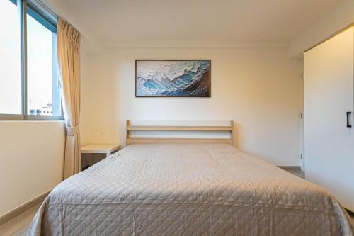 a bedroom with a bed with a picture on the wall at Hin Nan Hua Hin RELAX in Hua Hin