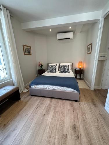 a bedroom with a large bed and wooden floors at La suite de Elise in Beaulieu-sur-Mer
