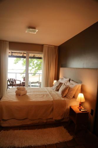a bedroom with a large bed with a window at Le Terrace in Morro de São Paulo