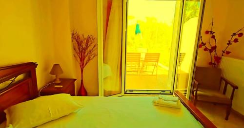 ein Schlafzimmer mit einem Bett und einer Glasschiebetür in der Unterkunft LECÉLESTE in Lithakia