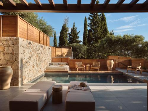 a backyard with a pool with chairs and a table at Horizon Collection in Agios Nikolaos