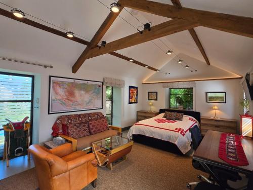 a bedroom with a bed and a couch and a table at Spacious Studio - Bicester Village & Silverstone in Middleton Stoney