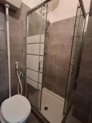 a bathroom with a toilet and a glass shower at Palazzo Ruisi in Scordia