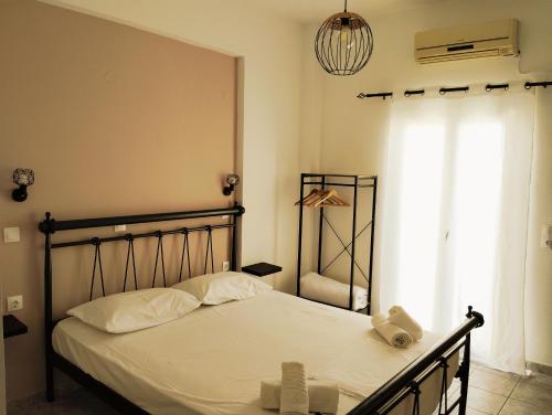 a bedroom with a bed with white sheets and a window at Studio Mary in Perissa