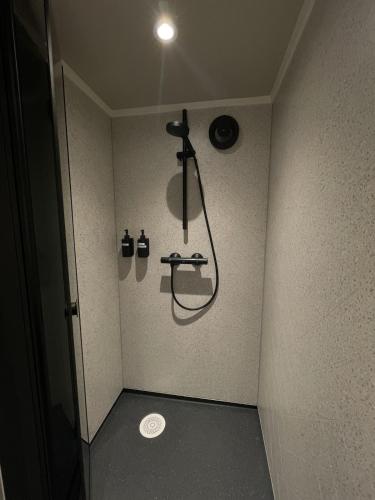 a small bathroom with a shower in the corner at Halden downtown apartment in Halden