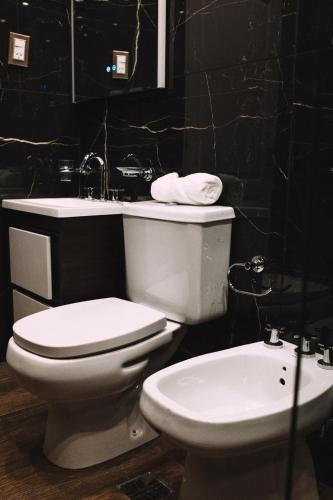 a bathroom with a toilet and a sink at Takuá Hotel Serrano in La Punta