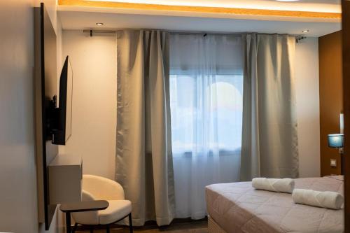 a bedroom with a bed and a window with curtains at Takuá Hotel Serrano in La Punta