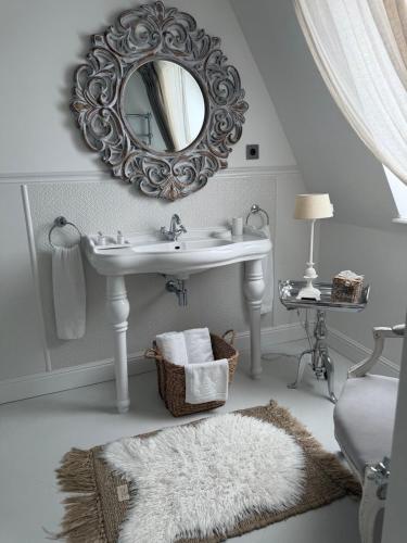 a white bathroom with a sink and a mirror at Villa Celine in Mielno