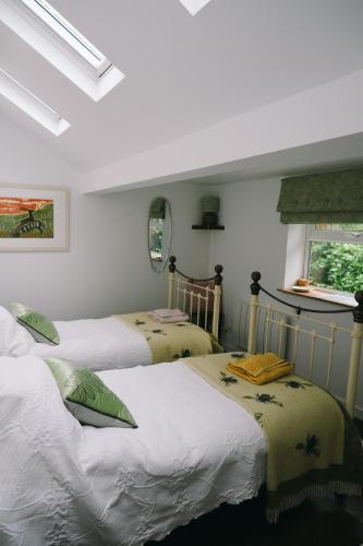a bedroom with two beds and a window at Little Woodacott in Barnstaple