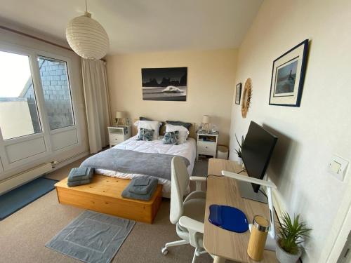 a bedroom with a bed and a desk with a computer at Ty avel in Crozon