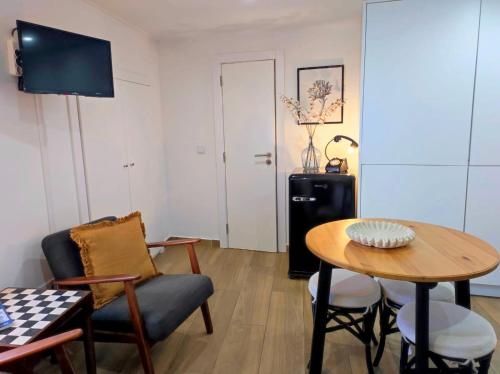 a living room with a table and chairs and a television at Entre Muralhas - Cozy Apartment Elvas I in Elvas