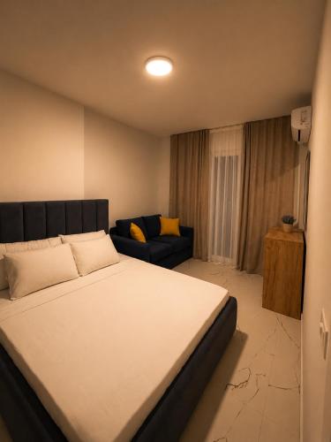 a bedroom with a large bed and a couch at Kron apartment in Shëngjin