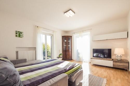 a large bedroom with a bed and a tv at Haus Dorfblick in Caldaro
