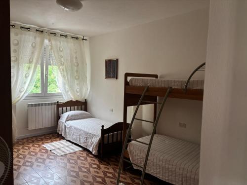 two bunk beds in a room with a window at Patty House in Colico
