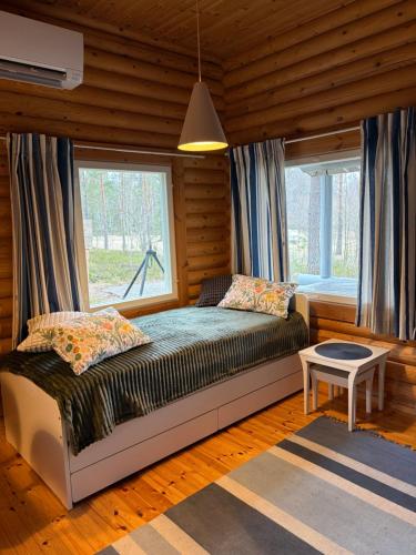 a bedroom with a bed and a window at Tamminiemen Lomamökit in Kustavi