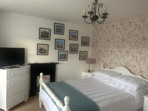 a bedroom with a bed and a dresser with a television at Glan Morfa in Morfa Nefyn