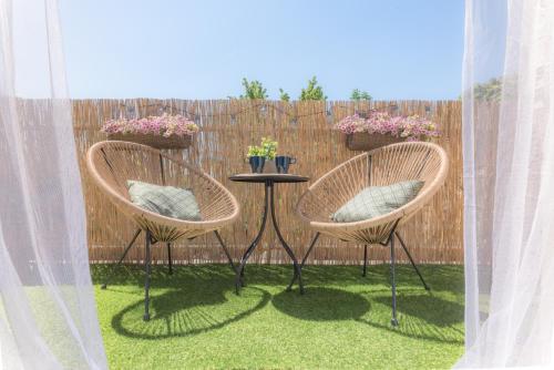 two chairs and a table in front of a fence at Captain's Quarters - with Terrace and Parking near Lake Balaton in Keszthely