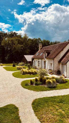 a house with a gravel driveway next to a building at MAISON MOZ entre Chambord & Cheverny in Fontaines-en-Sologne