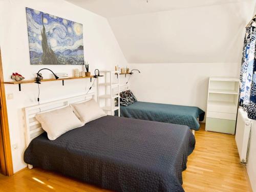 a bedroom with two beds and a painting on the wall at Apartment ZARJA in Dobrnič