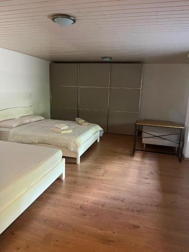 a room with two beds and a table in it at Le Chalet de la Coudre in Neuchâtel