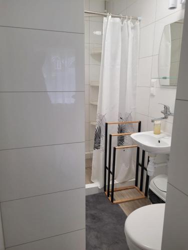a white bathroom with a sink and a toilet at Pod Sosnami 46 in Pobierowo
