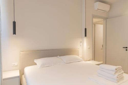 a bedroom with a white bed and a mirror at Aria Apartment 1 in Dhërmi